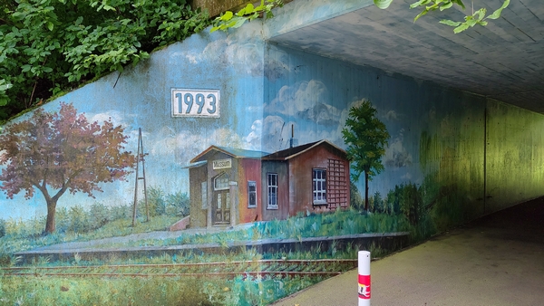 "Wandmalerei" eines unbekannten K&uuml;nstlers an der Stra&szlig;en&uuml;berquerung der B67 in Mussum. Diese erinnert an den urspr&uuml;nglichen Mussumer Bahnhof der Verbindung Empel-Rees - Bocholt - Borken - Coesfeld - M&uuml;nster. Quelle: eigenes Foto.